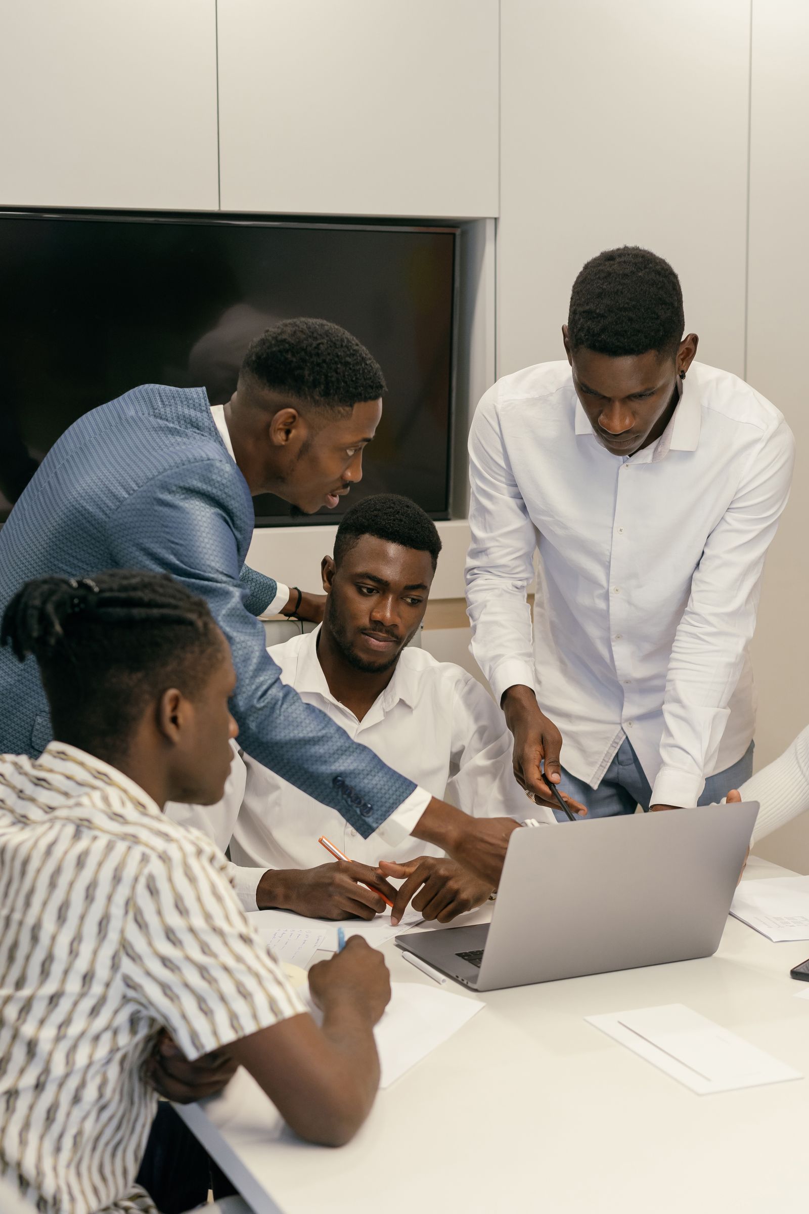 Team collaborating around a laptop